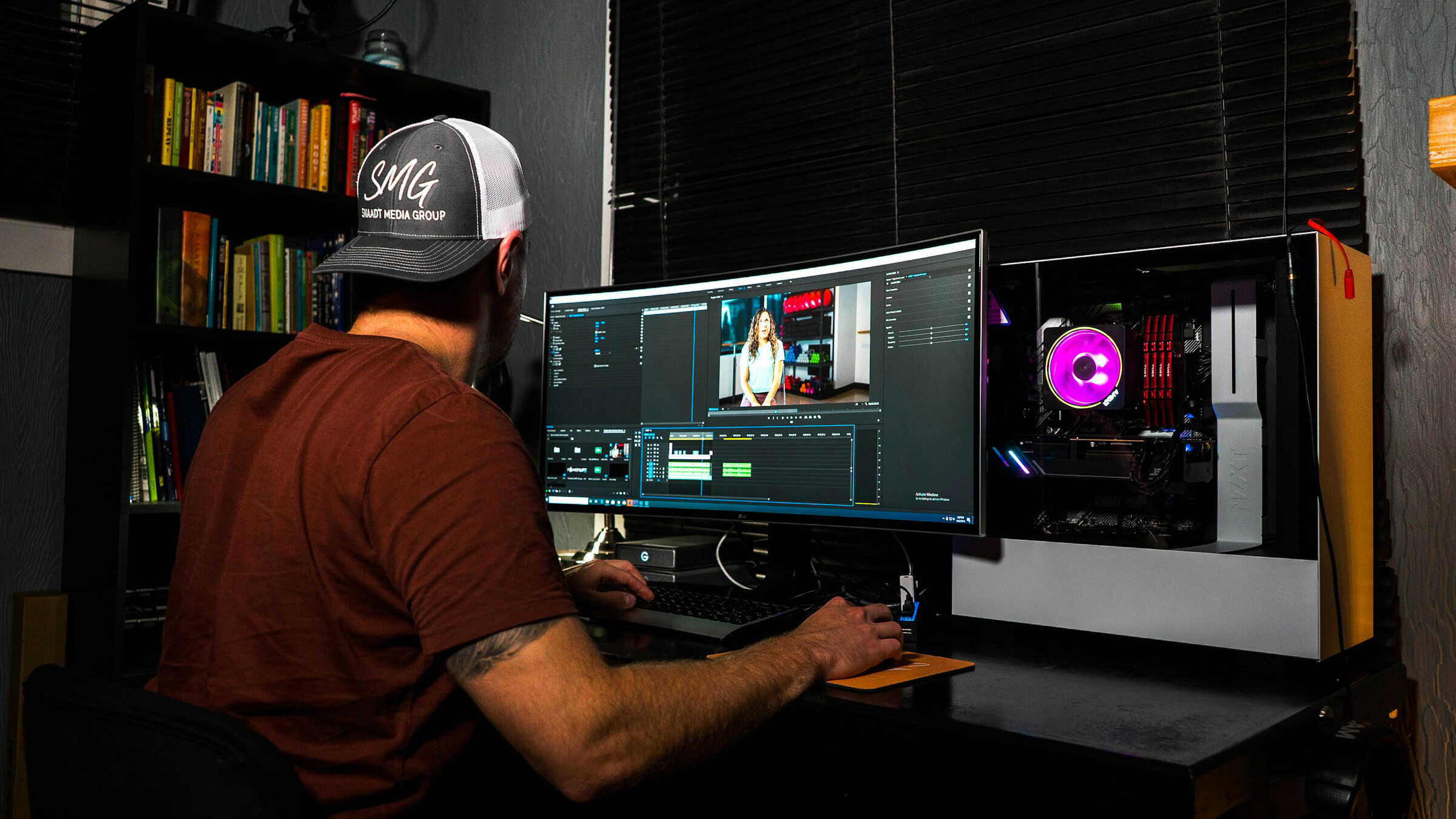 Man using video editing software on a curved monitor